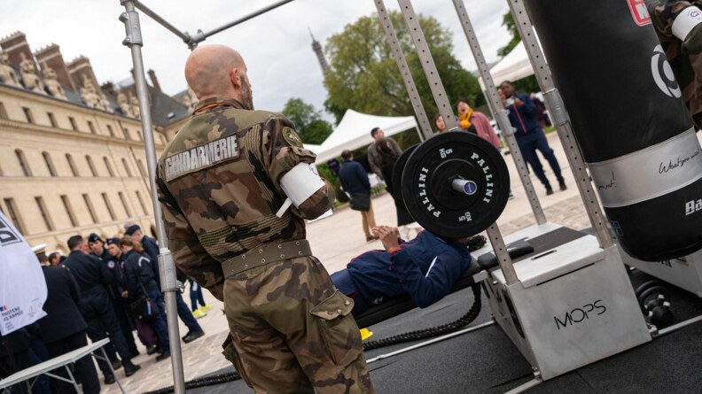 Un SHND d'une armée teste le parcours sportif, le développé couché à la barre, devant les Invalides