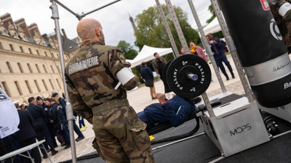 Un SHND d'une armée teste le parcours sportif, le développé couché à la barre, devant les Invalides
