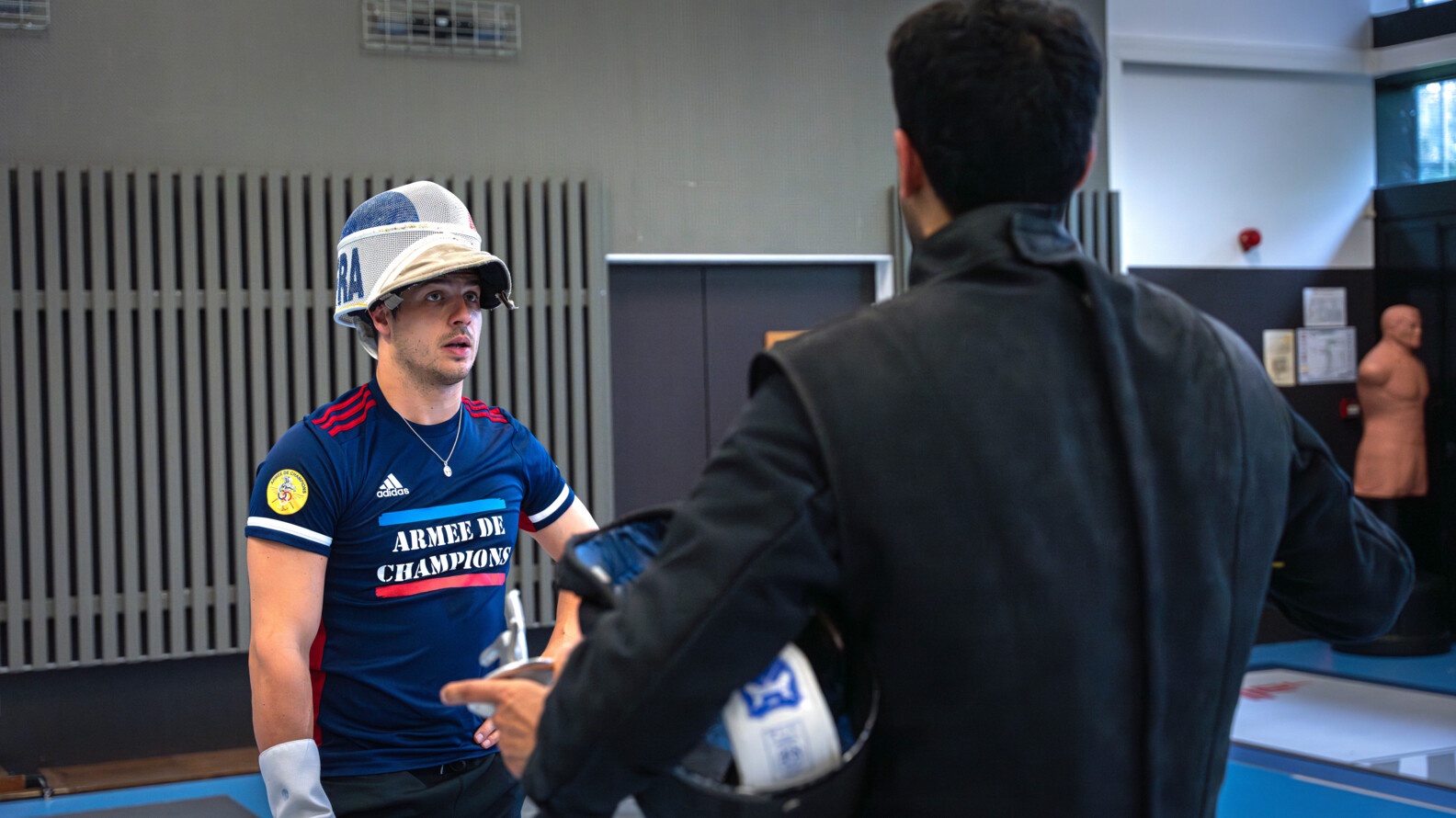 Facing his coach, helmet raised, Maxime Pauty looks at him as he talks with him