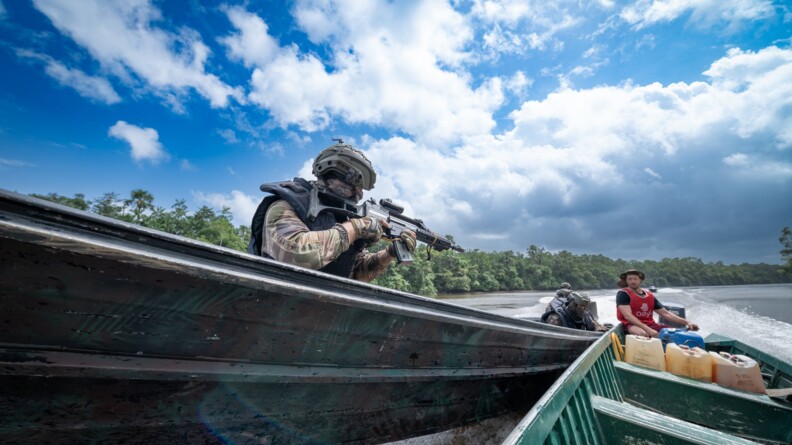 Gendarme de l'AGIGN pointant son arme en direction d'un garimpeiros en lui enjoignant d'arrêter sa pirogue.