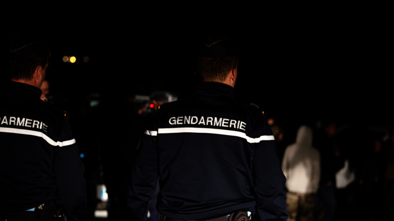 Deux gendarmes de dos, de nuit, lors de la rave party