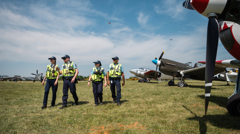 Quatre gendarmes de la GTA marchent devant des avions à l'arret