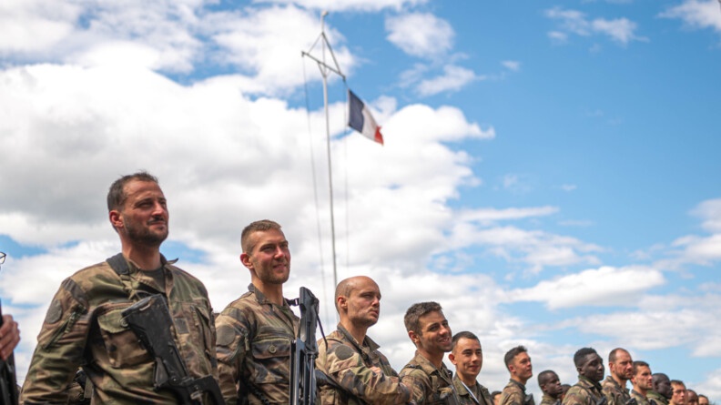 Nous voyons le drapeau français en arrière plan avec des élèves du 3ème peloton au premier plan