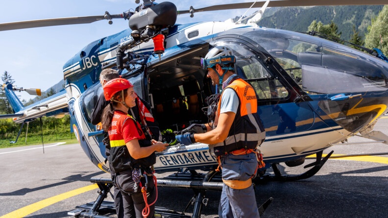 Echange entre un militaire du PGHM de Chamonix Mont Blanc et une secouriste des sapeurs pompiers devant l'hélicoptère EC 145 de la gendarmerie.