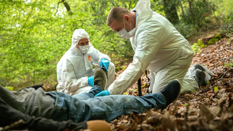 Les techniciens d'identification criminelle travaillent sur la découverte de cadavre, en tenue blanche