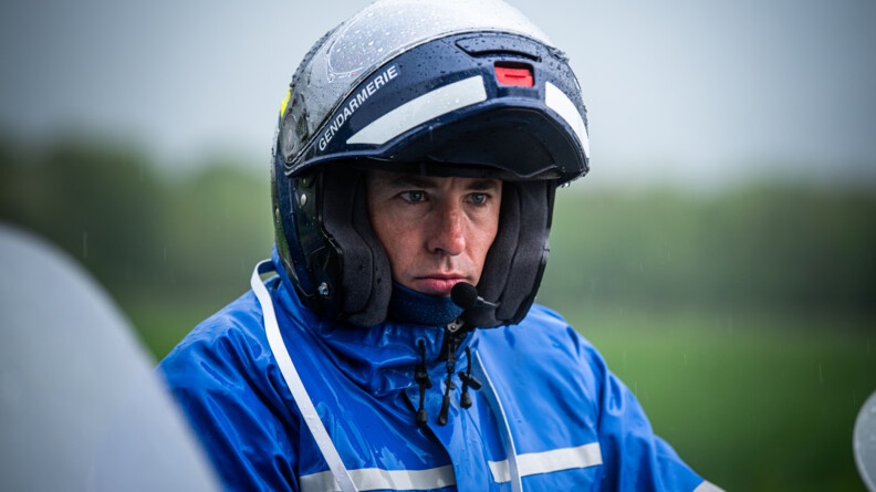 Portrait d'un gendarme motard sous la pluie avec son casque mouillé
