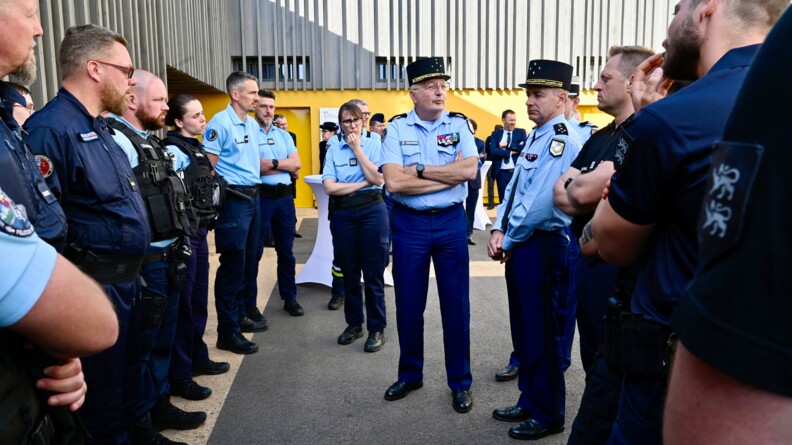 Le directeur général de la gendarmerie nationale entouré de nombreux gendarmes en tenue d'intervention, discute