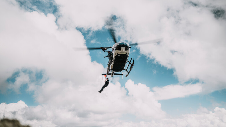 Un gendarme est hélitreuillé d'un hélicoptère gendarmerie dans le ciel nuageux