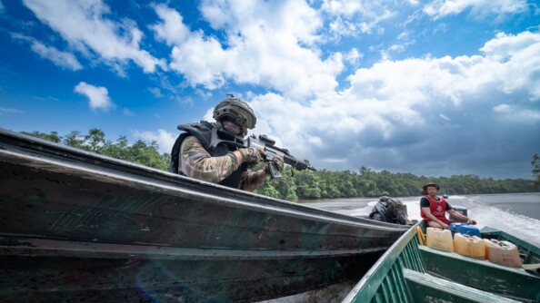 Gendarme de l'AGIGN pointant son arme en direction d'un garimpeiros en lui enjoignant d'arrêter sa pirogue.