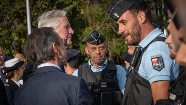 Le Premier ministre, Michel Barnier, accompagné du minsitre de l'Intérieur, Bruno Retailleau, se tenant de dos sur la photo, discute avec des gendarmes