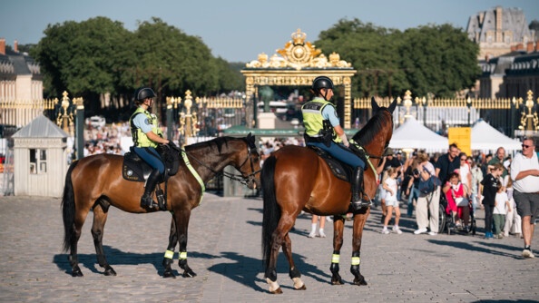 Deux cavalières de la Garde républicaine devant la foule et les grilles du château de Chambord
