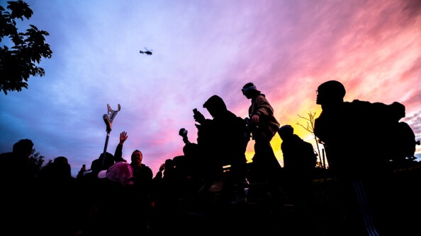 Des ravers regardent l'hélicoptère de la gendarmerie avec un magnifique coucher de soleil