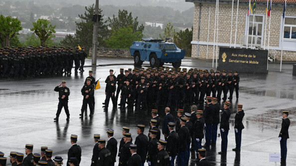 Un escadron de gendarmerie défile devant les autorités, sous la pluie
