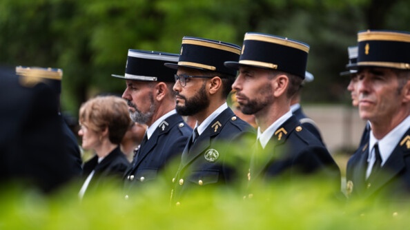Des militaires en uniforme bleu marine se tiennent debout, côte à côte, lors d'une cérémonie solennelle