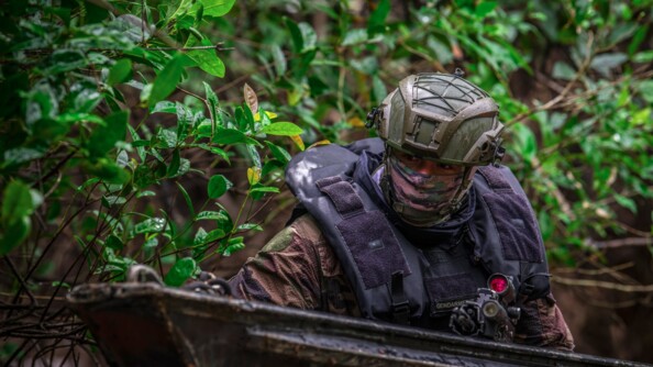 Gendarme de l'AGIGN dissimulé observant les pirogues sur le fleuve.