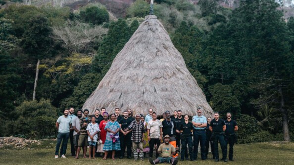 Gendarmes et membres de la tribu posant devant la case de la tribu.