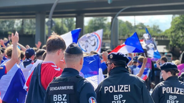 Un gendarme français et un policier de l'UOFA en encadrement de foule de supporters de football
