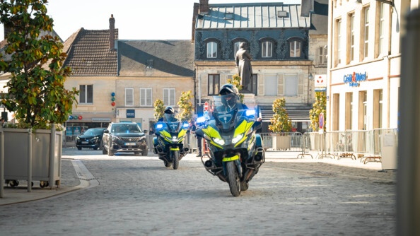 Des les rues du centre ville de Villers-Cotterêts, deux gendarmes motocyclistes précèdent deux voitures de couleur sombre