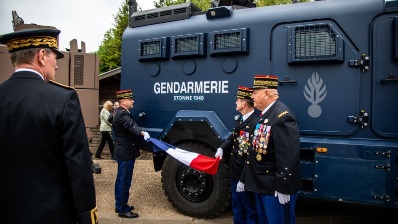 Agrandir l'image Deux généraux ôtent un drapeau apposé sur un véhicule Centaure dévoilant son nom de baptême "Stonne 1940".
